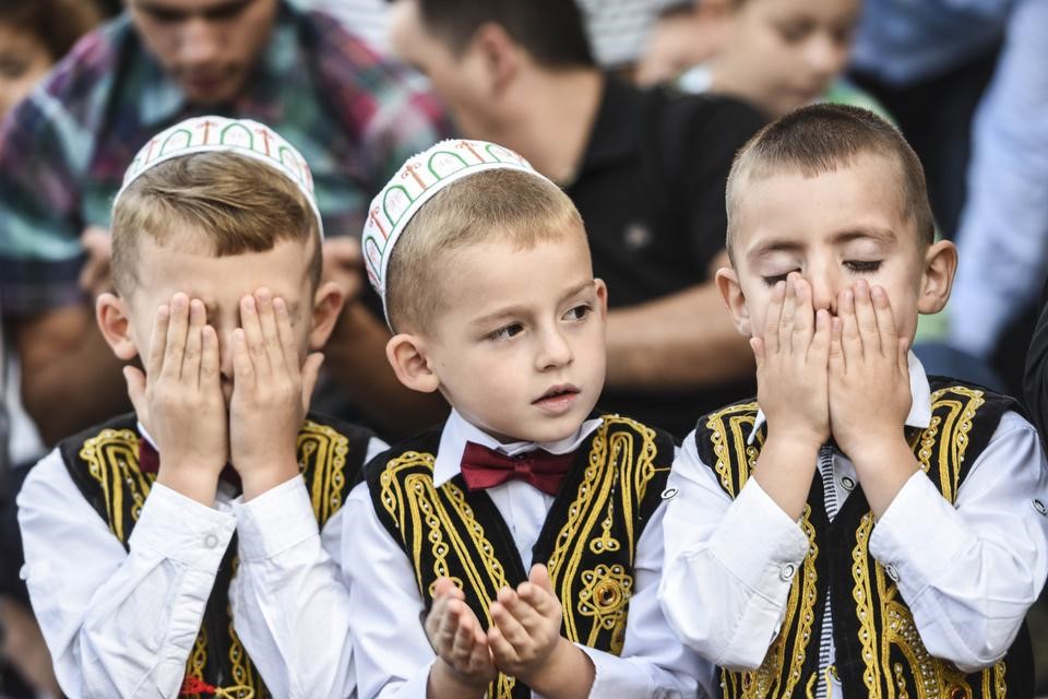 Three young Albanian boys celebrating Eid (Getty Images)